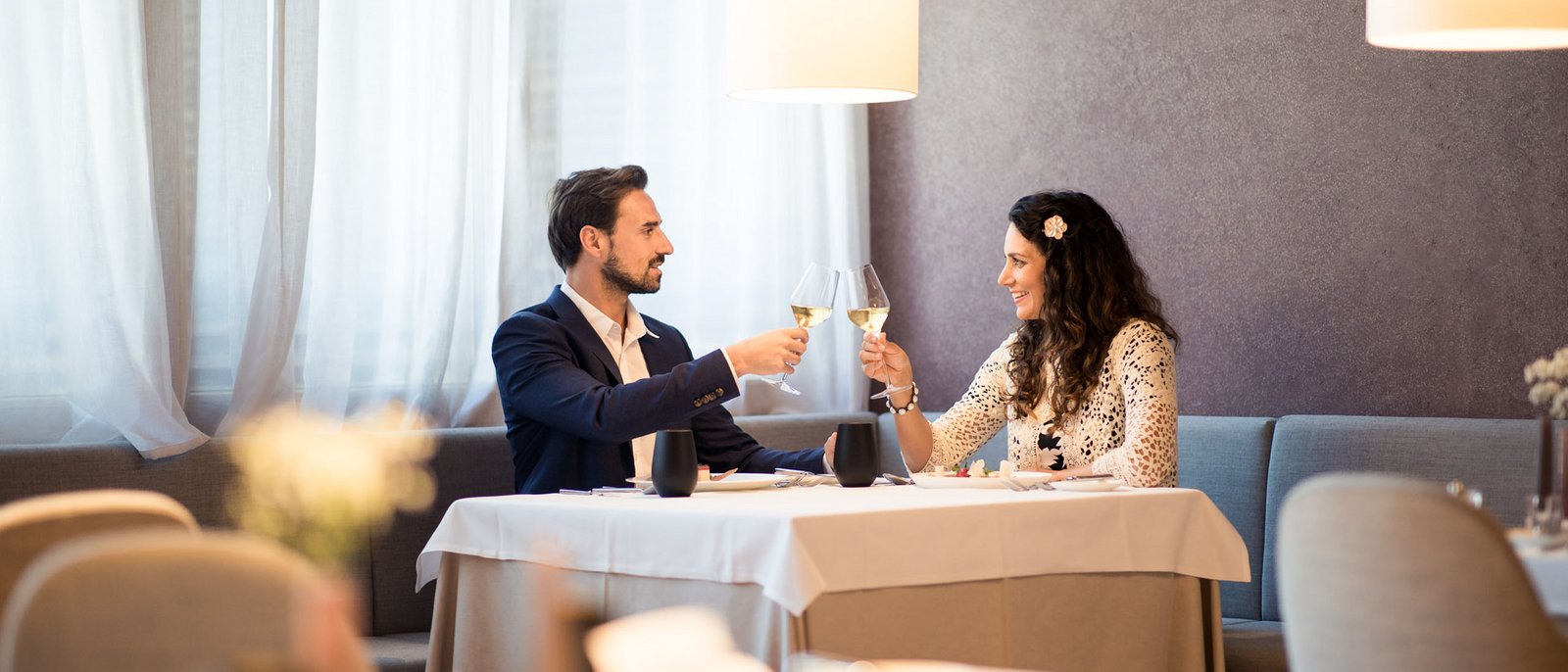 Silvester in Kastelruth Paar stößt mit Weingläsern in einem Restaurant an