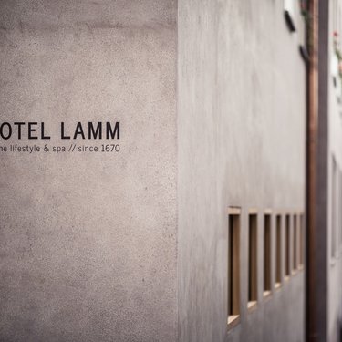 Facade of Hotel Lamm with alpine lifestyle & spa sign since 1670